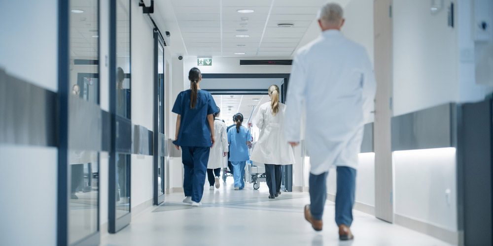 Hospital,Hallway,With,Doctors,,Nurses,And,Specialists,In,Hospital.,Female