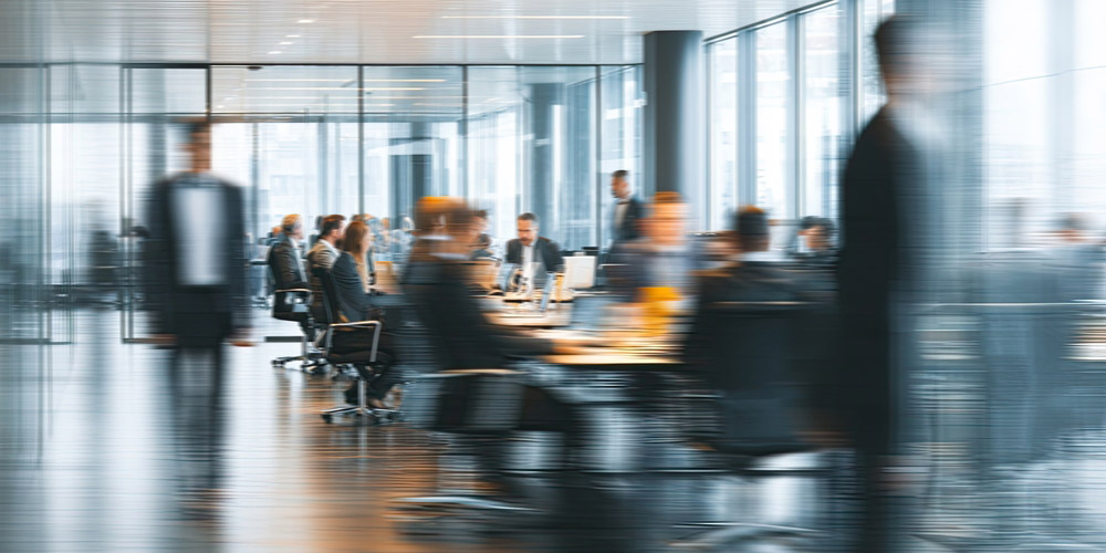 Busy,Modern,Office,Meeting,With,Blurred,Figures,In,Motion